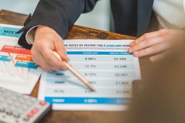 Une personne analyse des données financières avec un crayon et un calculateur sur une table