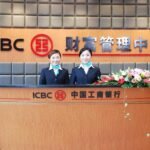 Deux femmes en uniforme devant un bureau ICBC avec des fleurs
